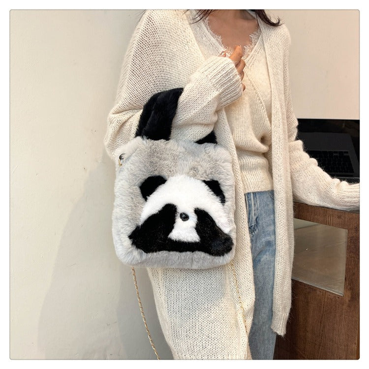 Person holding a panda-shaped bag with a plain background